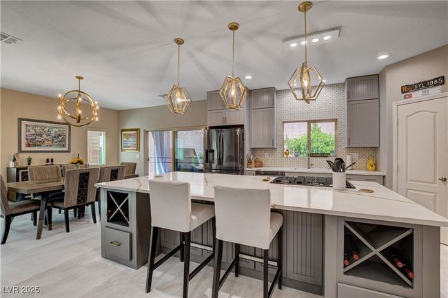 Kitchen featuring tasteful backsplash, a large island, stainless steel appliances, gray cabinetry | Image 23