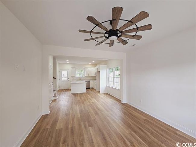 Unfurnished living room with light wood-type flooring, ceiling fan, baseboards, and a wealth of natural light | Image 24