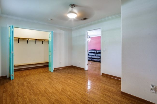 Unfurnished bedroom featuring crown molding, light wood-style flooring, and a closet | Image 17