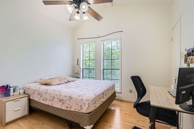 Bedroom with a ceiling fan, baseboards, lofted ceiling, and light wood-style floors | Image 18