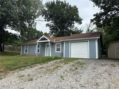 Single story home with a garage, a front lawn, and a storage shed | Image 1