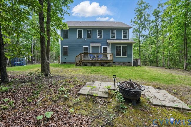 Back view of home with wooded backdrop and spacious yard. | Image 43