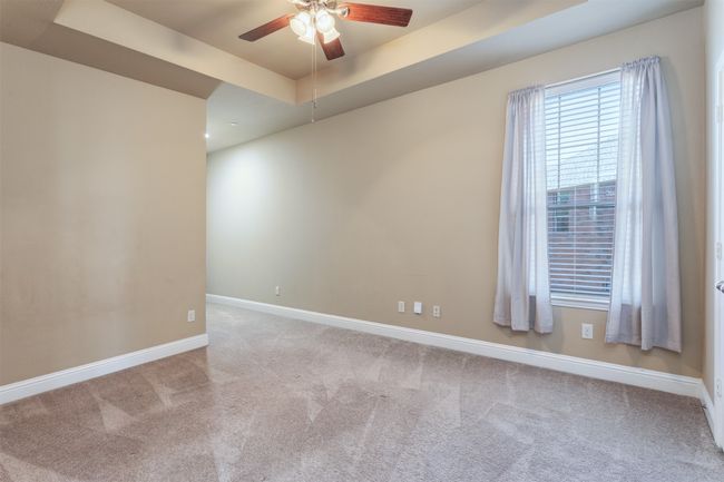 Spare room with ceiling fan, baseboards, carpet, and a tray ceiling | Image 25