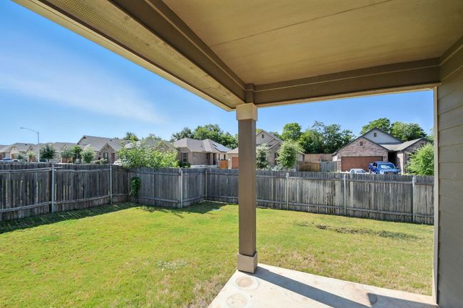 Fenced backyard with a residential view and a patio area | Image 26