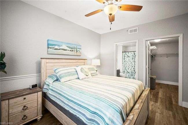 Bedroom featuring a walk in closet, dark wood-style flooring, connected bathroom, visible vents, and a closet | Image 18