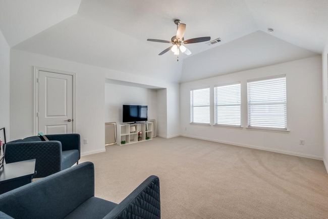 Living room featuring ceiling fan, vaulted ceiling, light carpet, and baseboards | Image 25