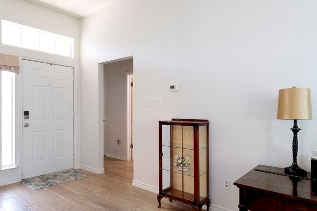 Foyer entrance with light wood-style floors and a high ceiling | Image 4
