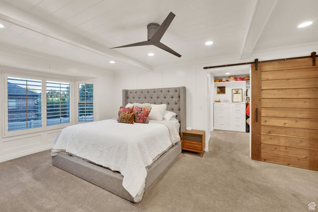Carpeted bedroom featuring beamed ceiling, a barn door, recessed lighting, and ceiling fan | Image 17