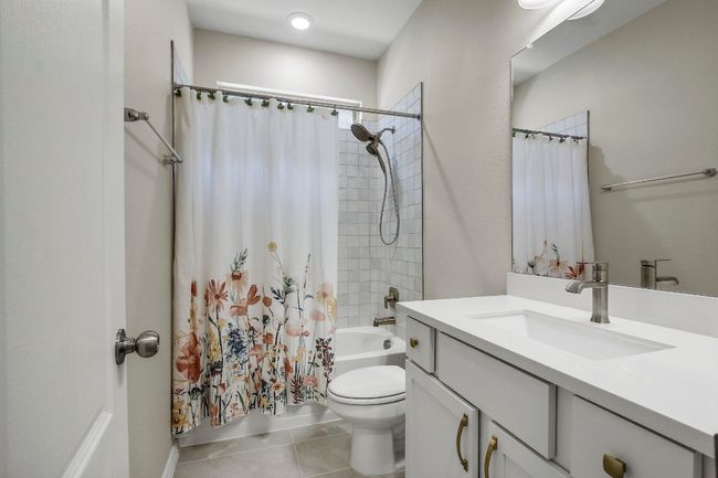 Full bathroom featuring vanity, shower / bath combo, and tile patterned floors | Image 24
