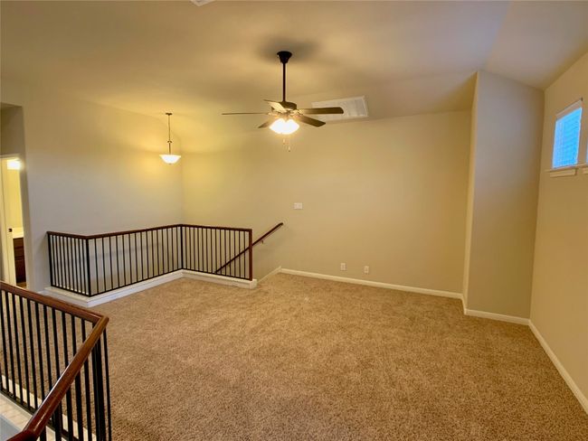 Carpeted empty room featuring vaulted ceiling, a ceiling fan, and baseboards | Image 6