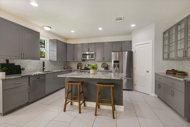 Kitchen with gray cabinets, appliances with stainless steel finishes, tasteful backsplash, and recessed lighting | Image 7