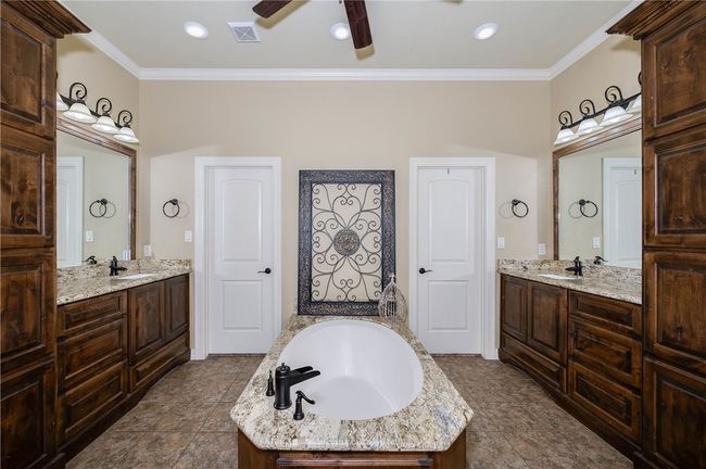 Bathroom featuring two vanities, a soaking tub, and double sided walk-in closet | Image 18