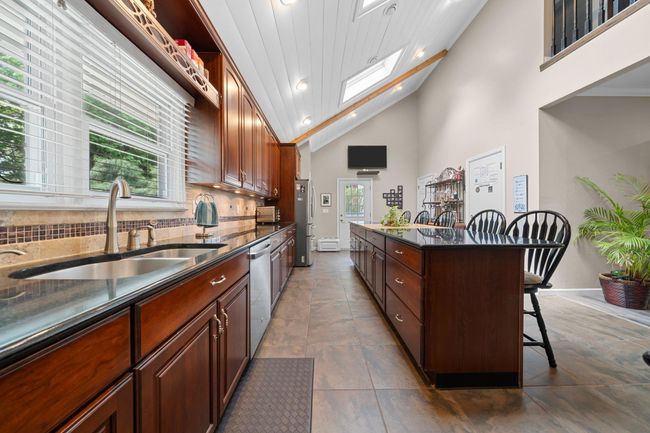Half bath featuring wainscoting, toilet, vanity, and tile patterned flooring | Image 19