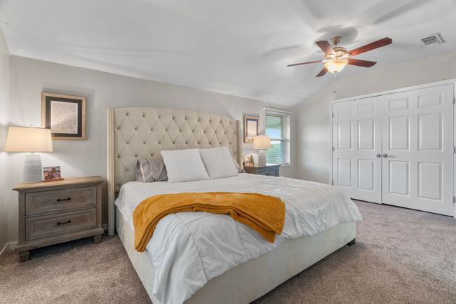 Bedroom with carpet floors, a closet, vaulted ceiling, and ceiling fan | Image 25