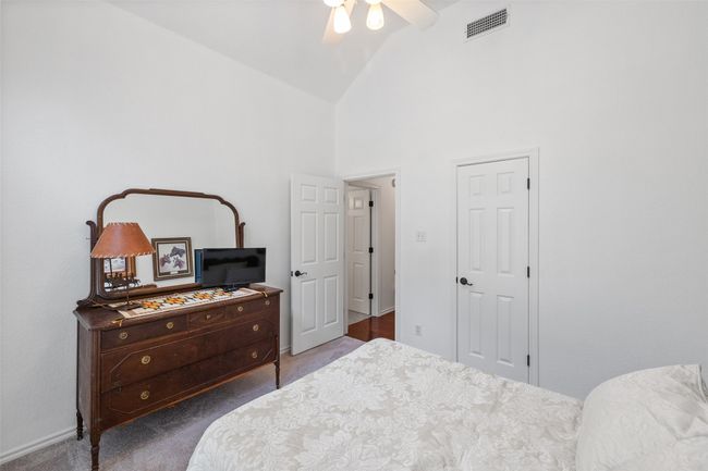 Carpeted bedroom featuring high vaulted ceiling, visible vents, and a ceiling fan | Image 20