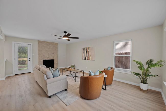 Living area with a ceiling fan, light wood-style flooring, baseboards, and a wealth of natural light | Image 5