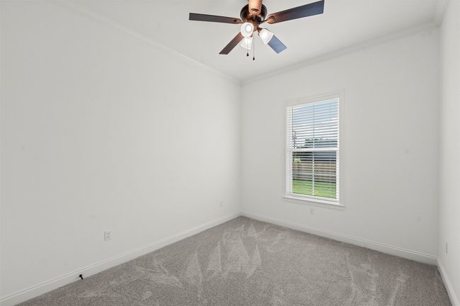 Empty room with carpet flooring, ornamental molding, and a ceiling fan | Image 26