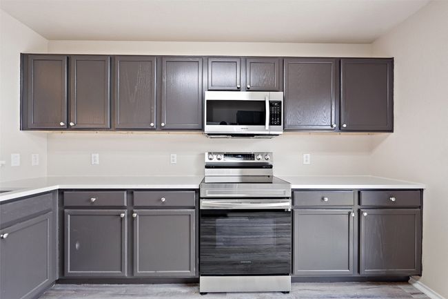 Kitchen with appliances with stainless steel finishes, gray cabinets, and light wood-type flooring | Image 10