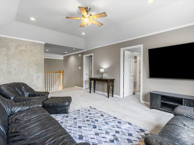 Living area with carpet, ceiling fan, ornamental molding, recessed lighting, and vaulted ceiling | Image 26