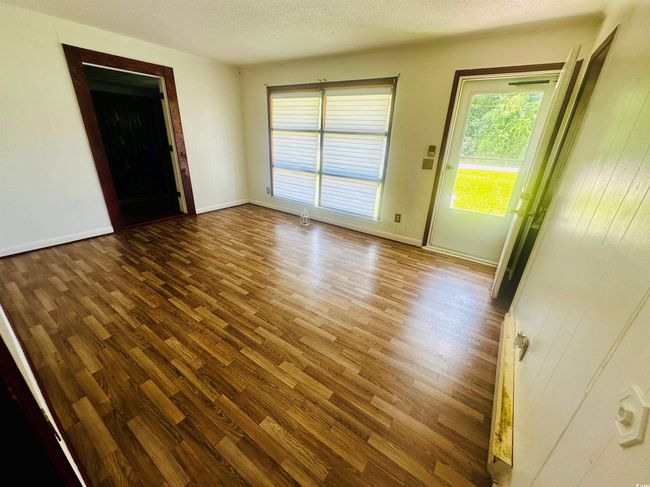Unfurnished room featuring wood finished floors, baseboards, and a textured ceiling | Image 4