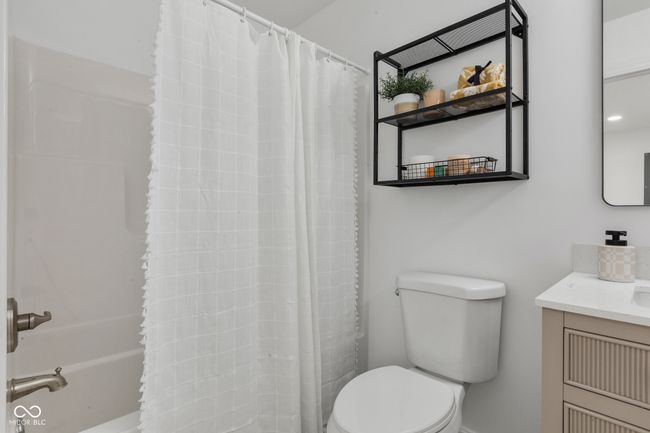 bathroom with a shower with shower curtain, vanity, and toilet | Image 48