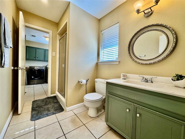 Full bathroom with separate washer and dryer, tile patterned flooring, toilet, and a shower stall | Image 28