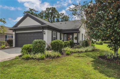 Ranch-style house with a front lawn and a garage | Image 2