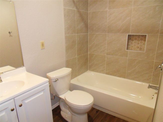 Bathroom featuring vanity, wood finished floors, toilet, and shower / bathtub combination | Image 7