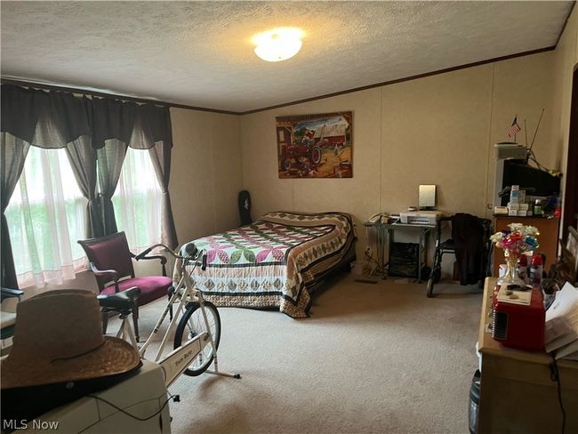 Bedroom featuring a textured ceiling and carpet floors | Image 11