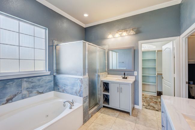 Bathroom featuring separate shower and tub, vanity, tile patterned flooring, and crown molding | Image 14