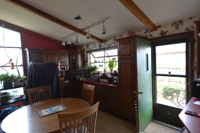 dining space featuring light tile patterned flooring and vaulted ceiling with beams | Image 14