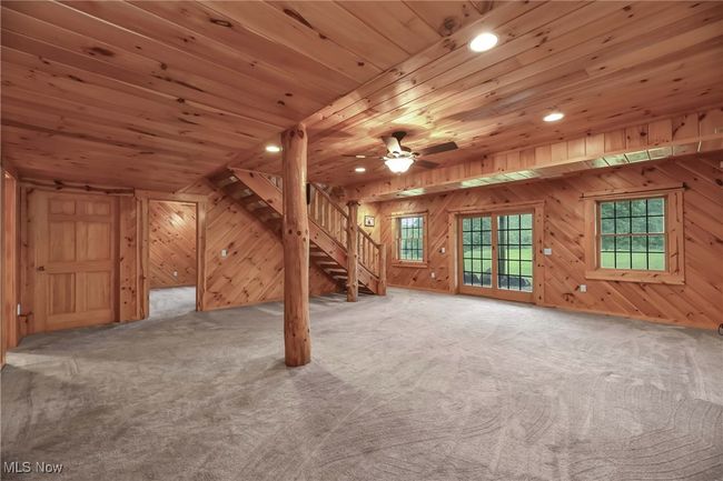 View of rec room toward stairwell, door to lower level bedroom | Image 34