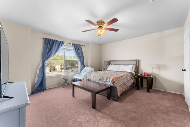 Bedroom featuring light carpet, baseboards, and ceiling fan | Image 15