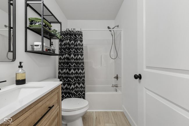 bathroom featuring shower / tub combo with curtain, vanity, toilet, and wood finished floors | Image 39