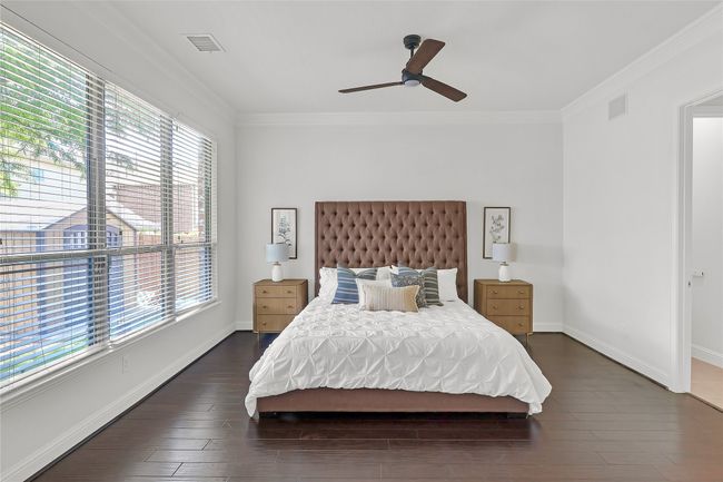 Bedroom with multiple windows, crown molding, dark wood-type flooring, and ceiling fan | Image 12