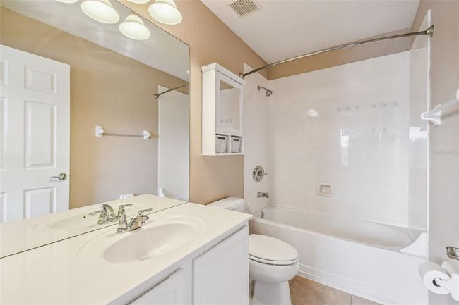 The second upstairs bedroom offers an en-suite bathroom with a shower/tub combo and a serene view of the pond. | Image 21