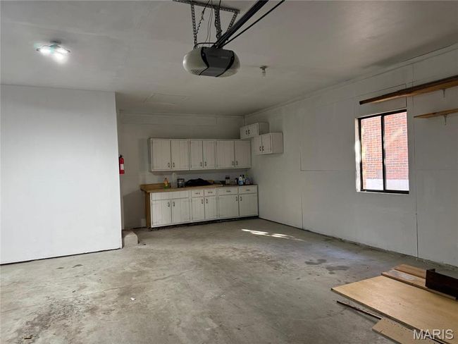 Garage with a garage door opener, extra storage/work area | Image 46