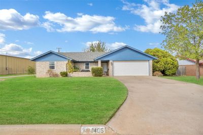 Ranch-style home featuring a front yard and a garage | Image 1