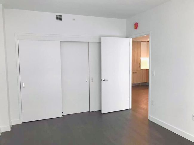 Unfurnished bedroom with a closet and dark wood-type flooring | Image 6