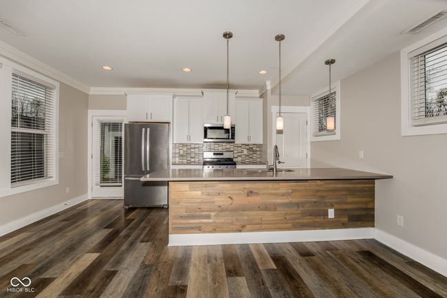 kitchen featuring stainless steel appliances, visible vents, a sink, decorative backsplash, and white cabinetry | Image 13