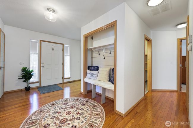 Bright and inviting main entrance welcomes you with an abundance of natural light. Step inside to stunning hardwood floors in a home that has been lovingly maintained. | Image 6