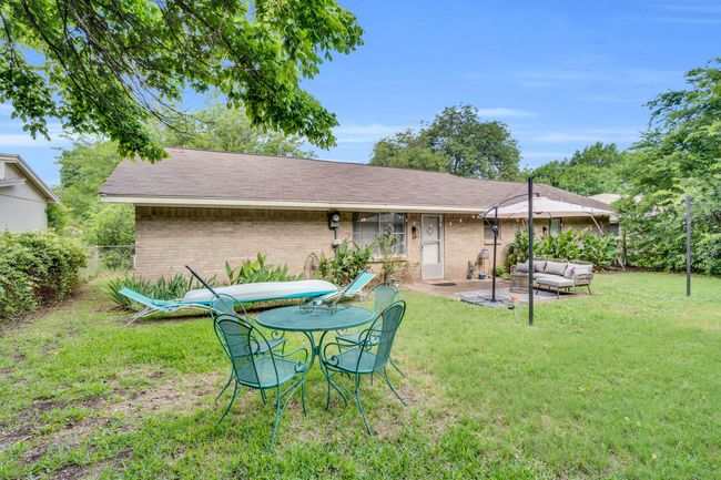 Rear view of house with brick siding, outdoor lounge area, a patio, and roof with shingles | Image 23
