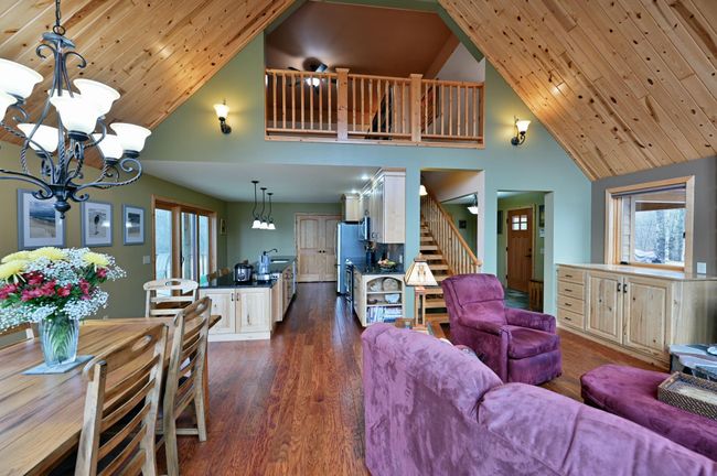 A view from the deck to the dining and living area with kitchen beyond and loft above. | Image 22