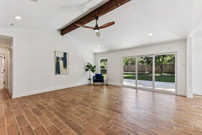 Exposed beams and expansive windows flood the living area with natural light. | Image 6