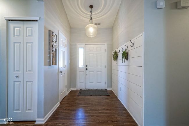 doorway with baseboards, visible vents, and dark wood-type flooring | Image 6