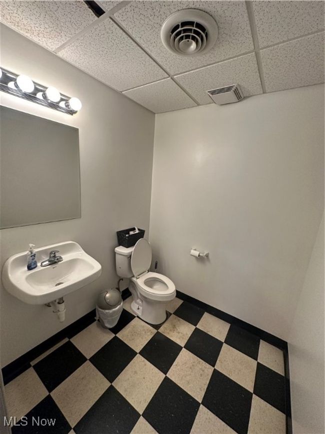 Bathroom with toilet, sink, and a drop ceiling | Image 13