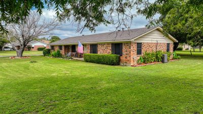 Ranch-style home with a front yard and cooling unit | Image 1