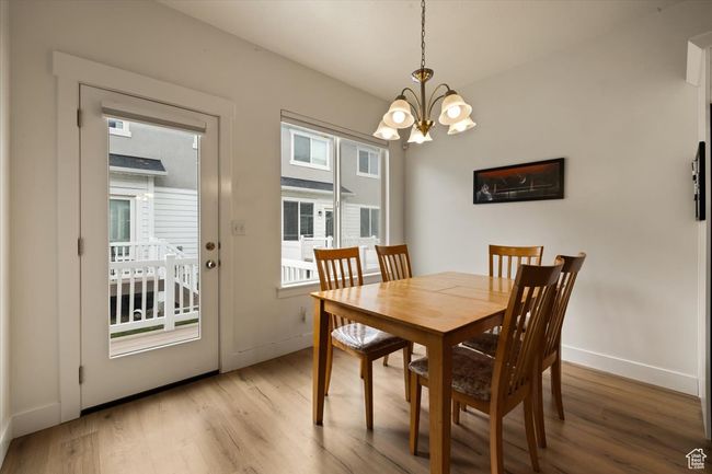 Dining space with baseboards, a chandelier, and light wood-type flooring | Image 25