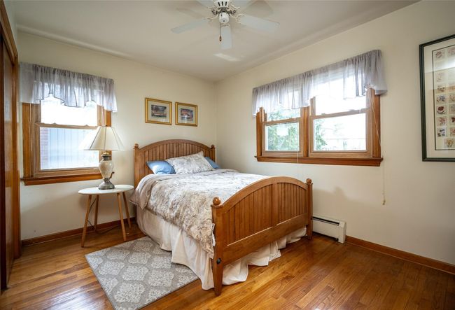 Bedroom 3 with ceiling fan, wood floors & dbl closet | Image 9