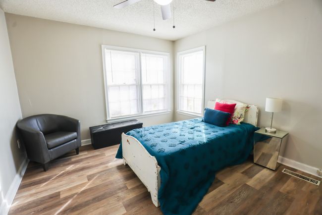 Bedroom featuring visible vents, a textured ceiling, baseboards, and wood finished floors | Image 25